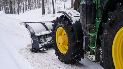 Cleaning machine is removing snow from road Big special tractor is removing snow from the forestal road.